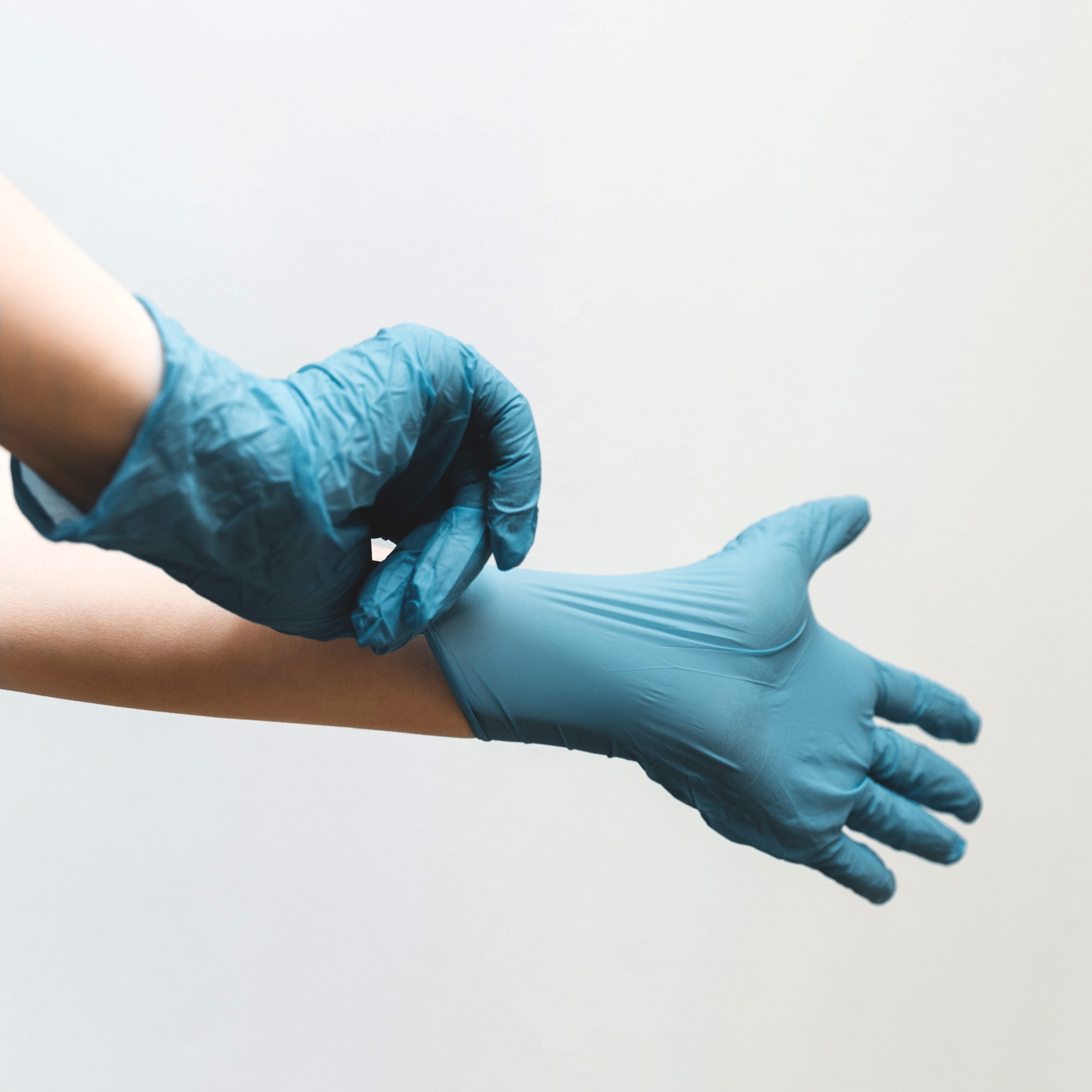 "Person putting on nitrile gloves"
