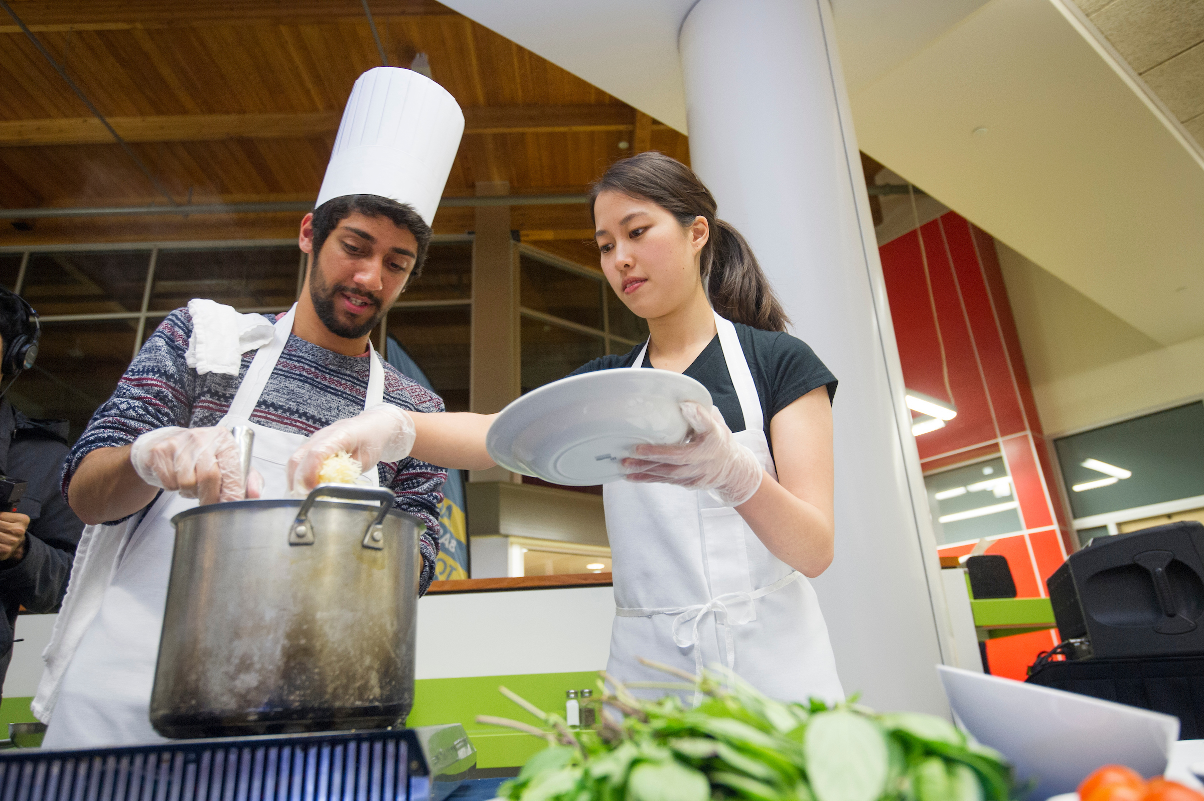 two students cooking in the Segundo Dining Commons for a cooking competition