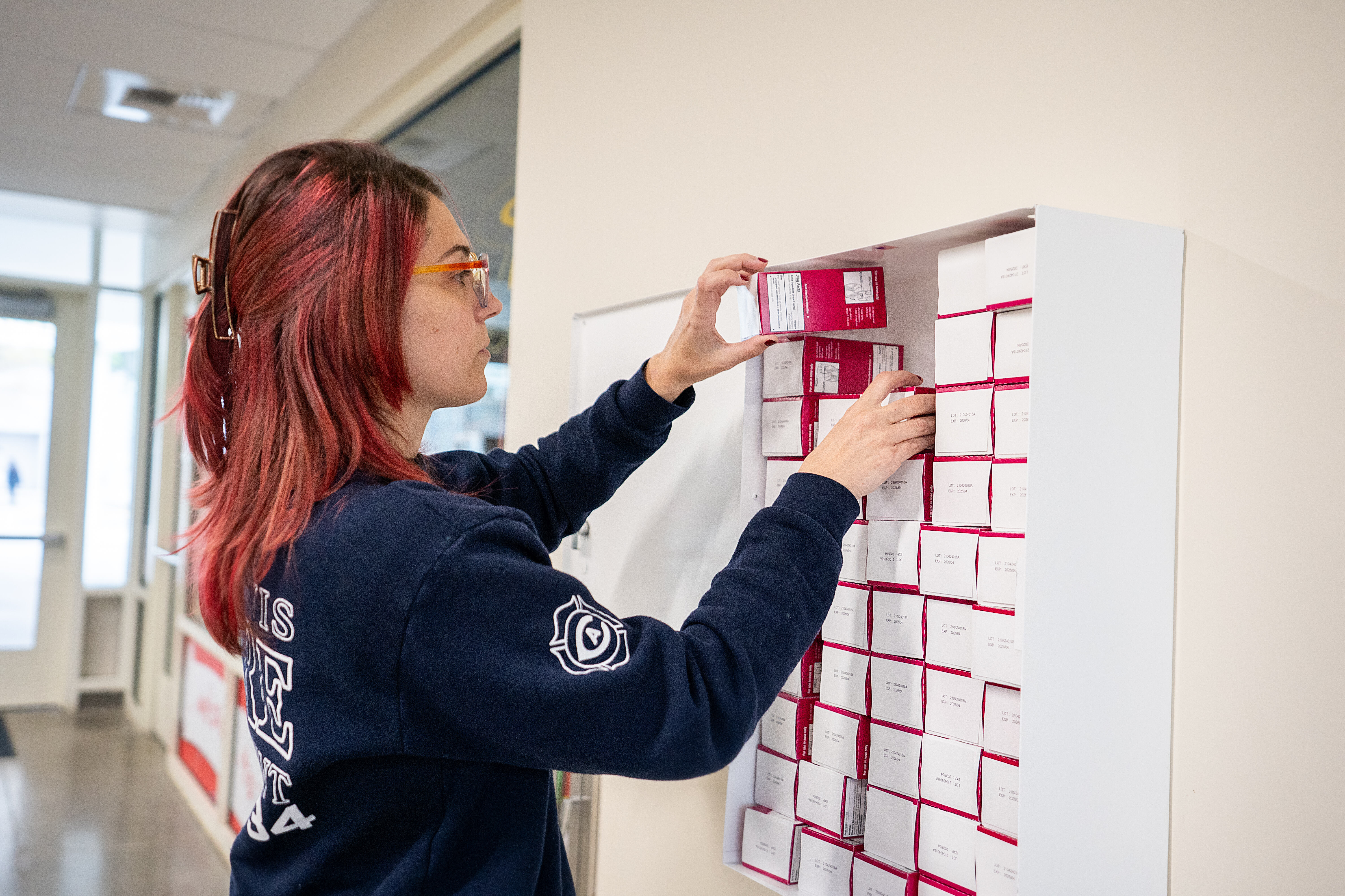 A UC Davis EMT student stocks a Narcan cabinet in the Memorial Union.