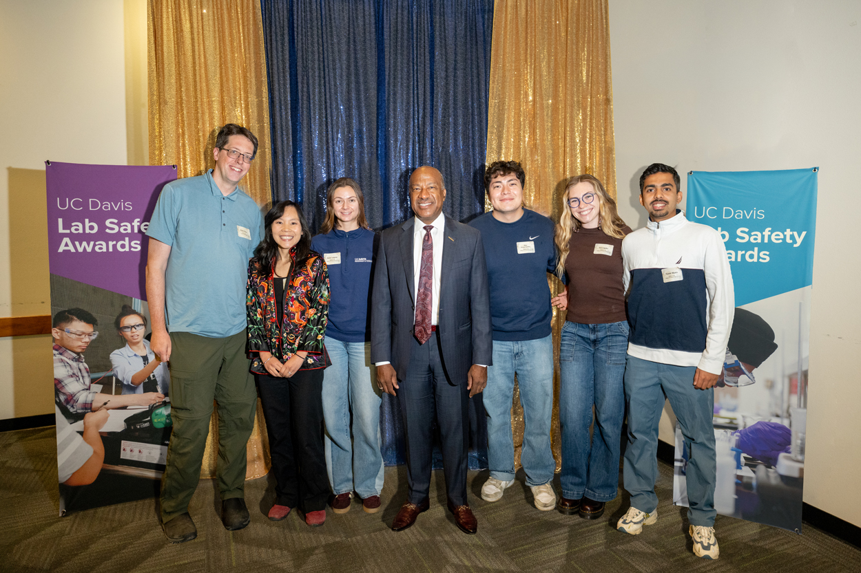Group photo of seven people at UC Davis Safety Awards, blue and gold backdrop