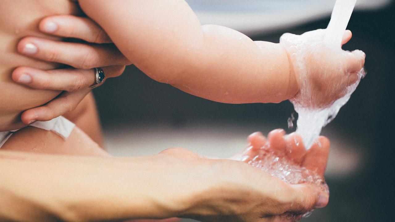 adult and child washing their hands under running water