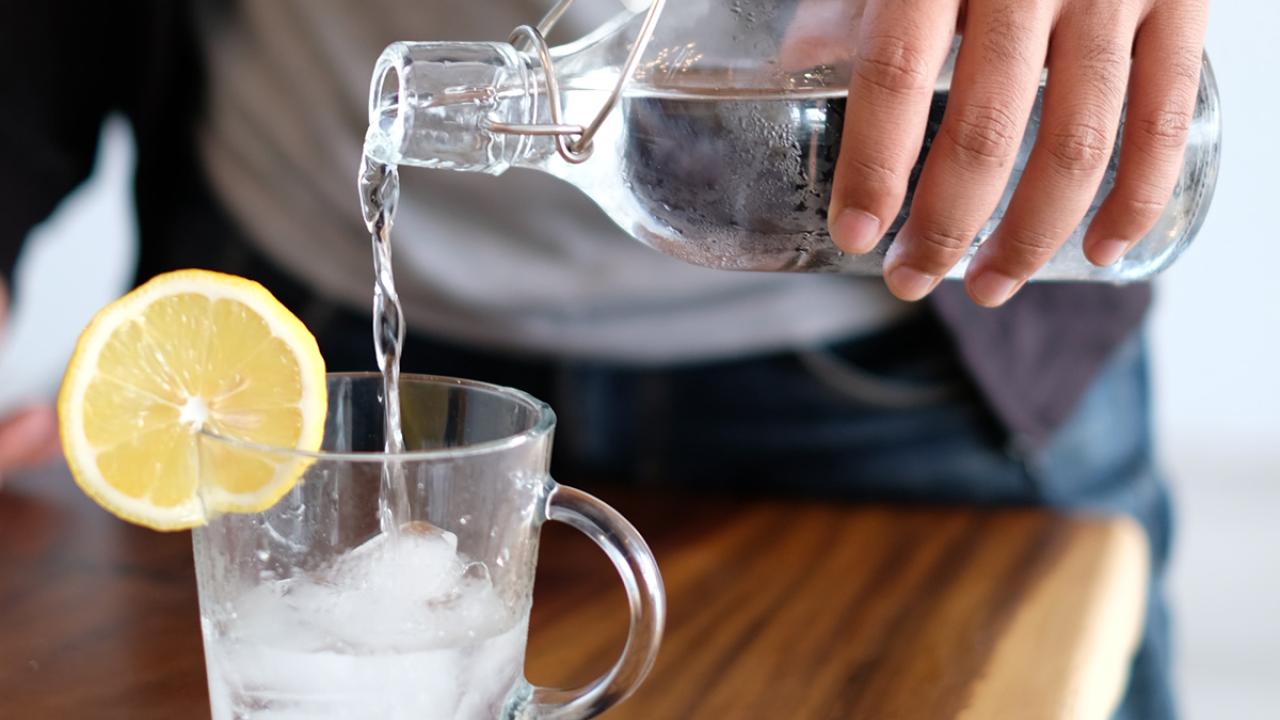 man pouring water into a glass