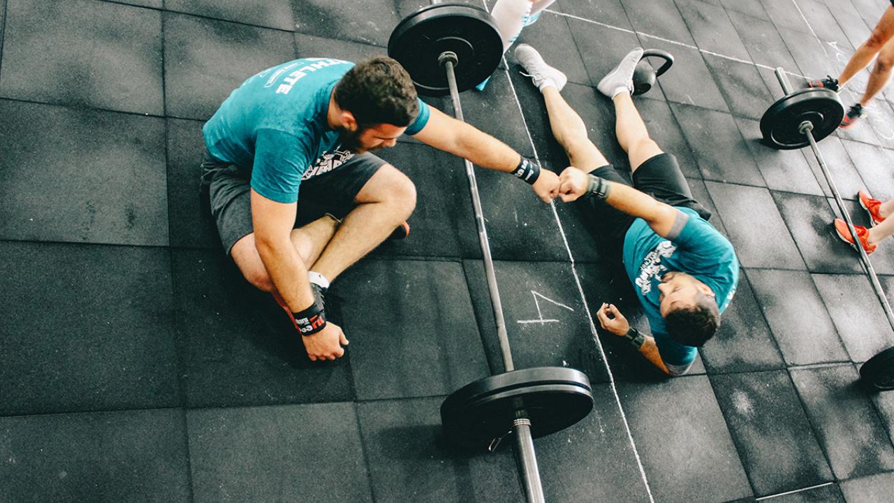 two men bumping fists at the gym