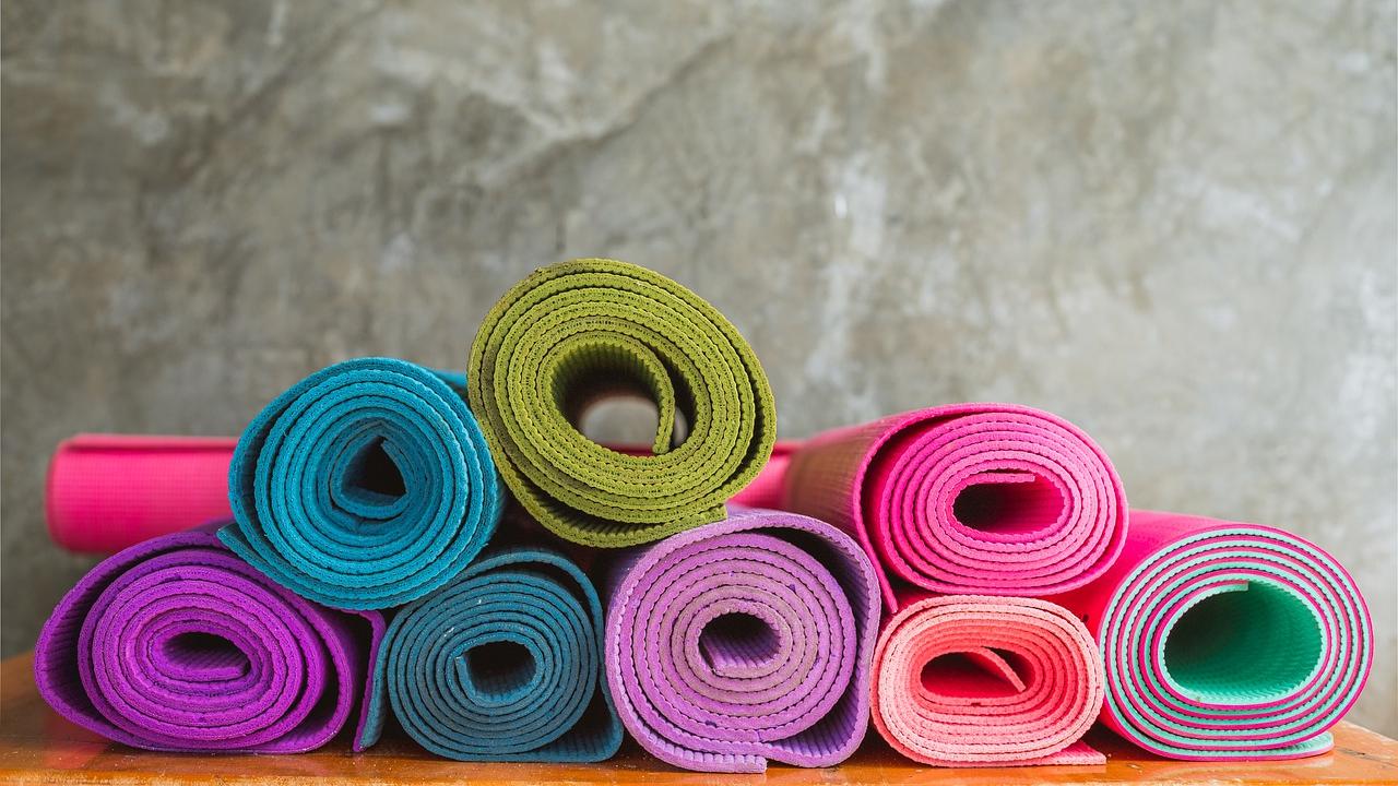 Pile of rolled up yoga mats in various bright colors