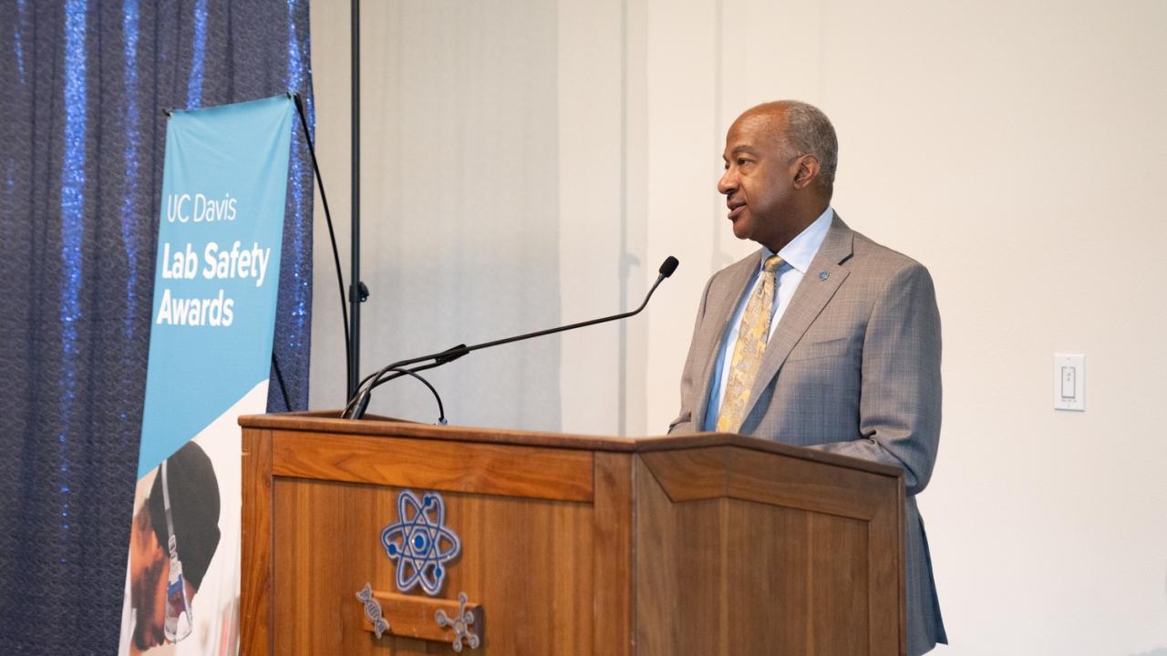 Chancellor Gary May stands at a lecturn and speaks.