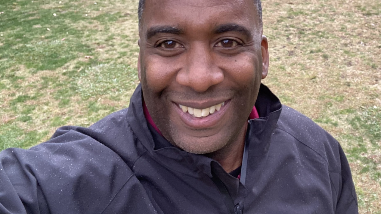 Black man smiling in park.