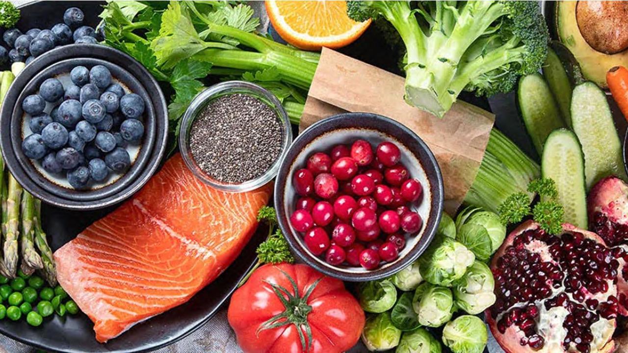 Salmon, blueberries, carrots, and other healthy foods arranged on a table