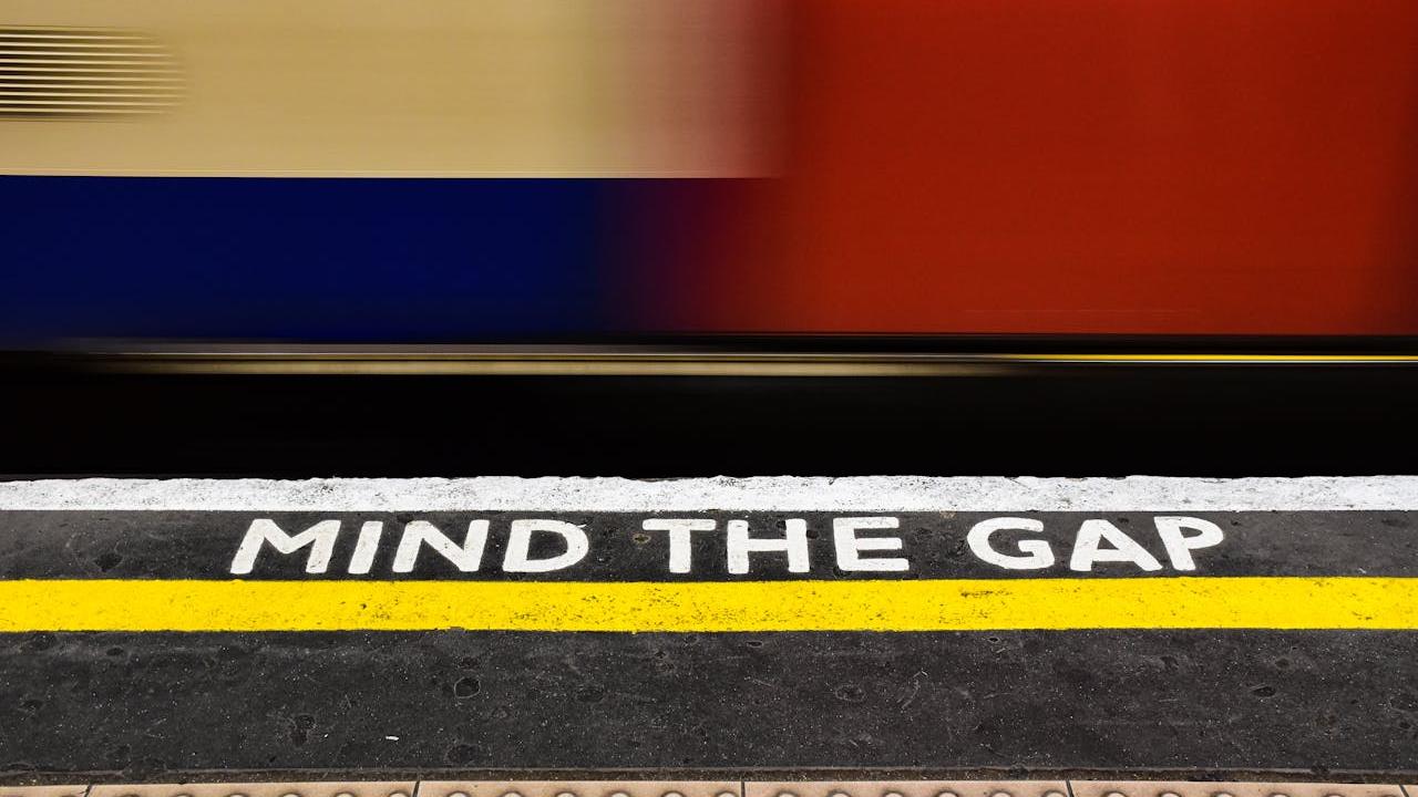 Mind the gap caution text on a train platform