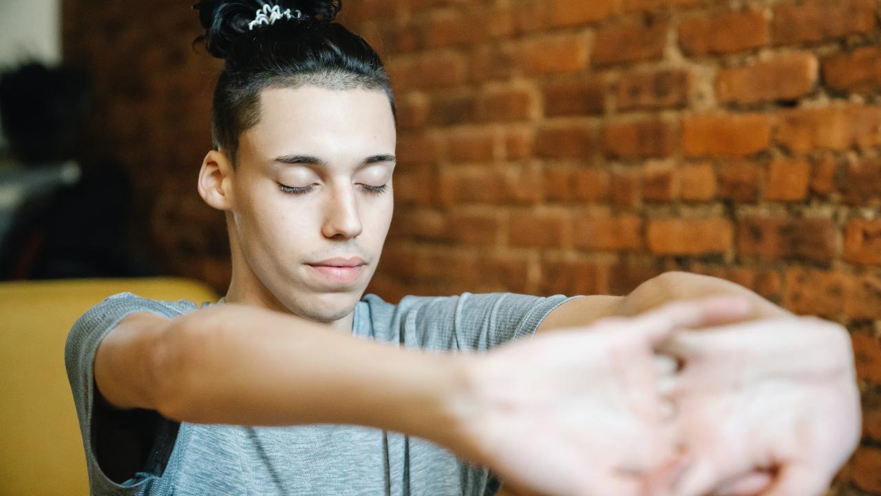 person sitting with hands interlocked and arms stretching