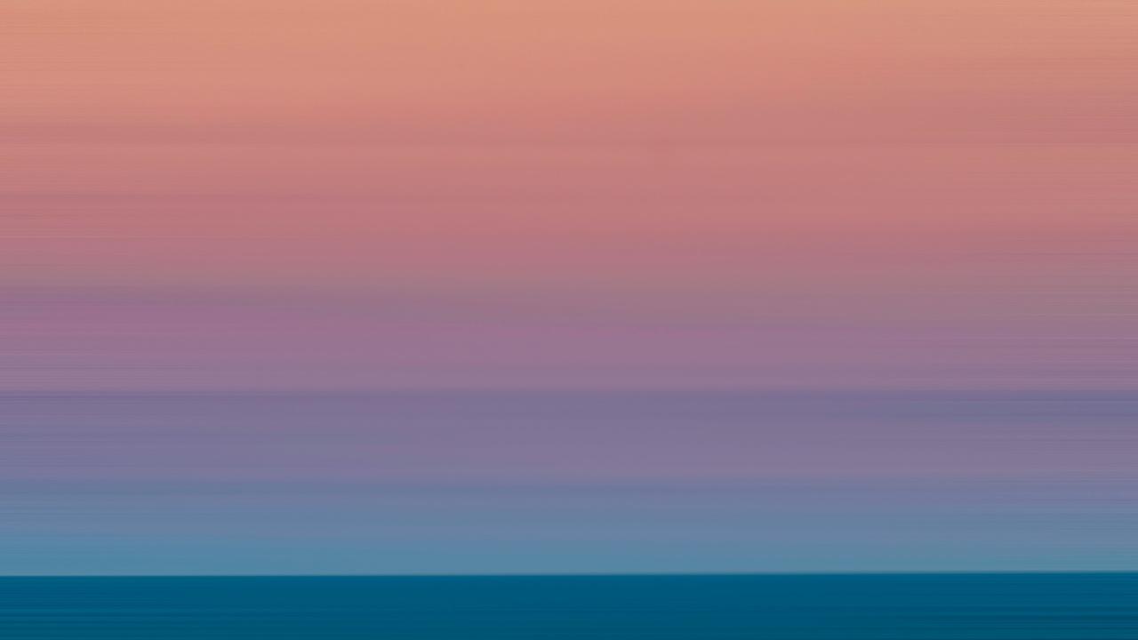 pink, orange, and yellow sunset with a blue ocean horizon