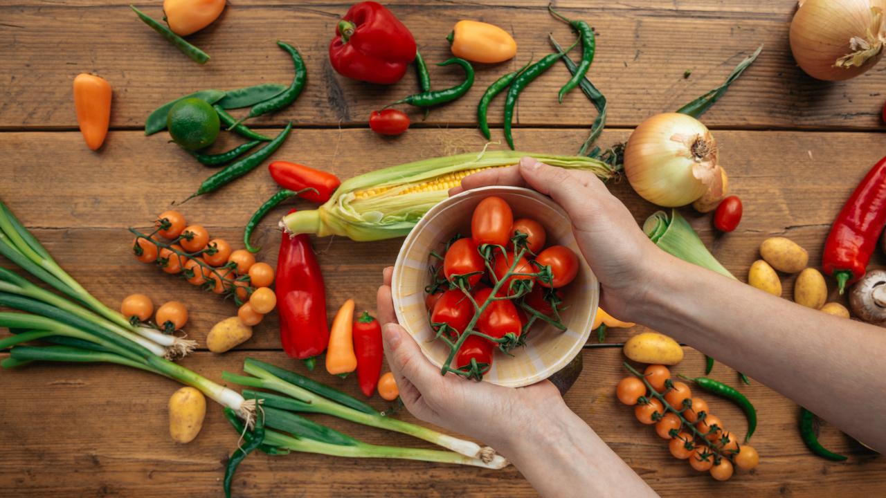 Person Holding a Bowl with Red Tomatoes