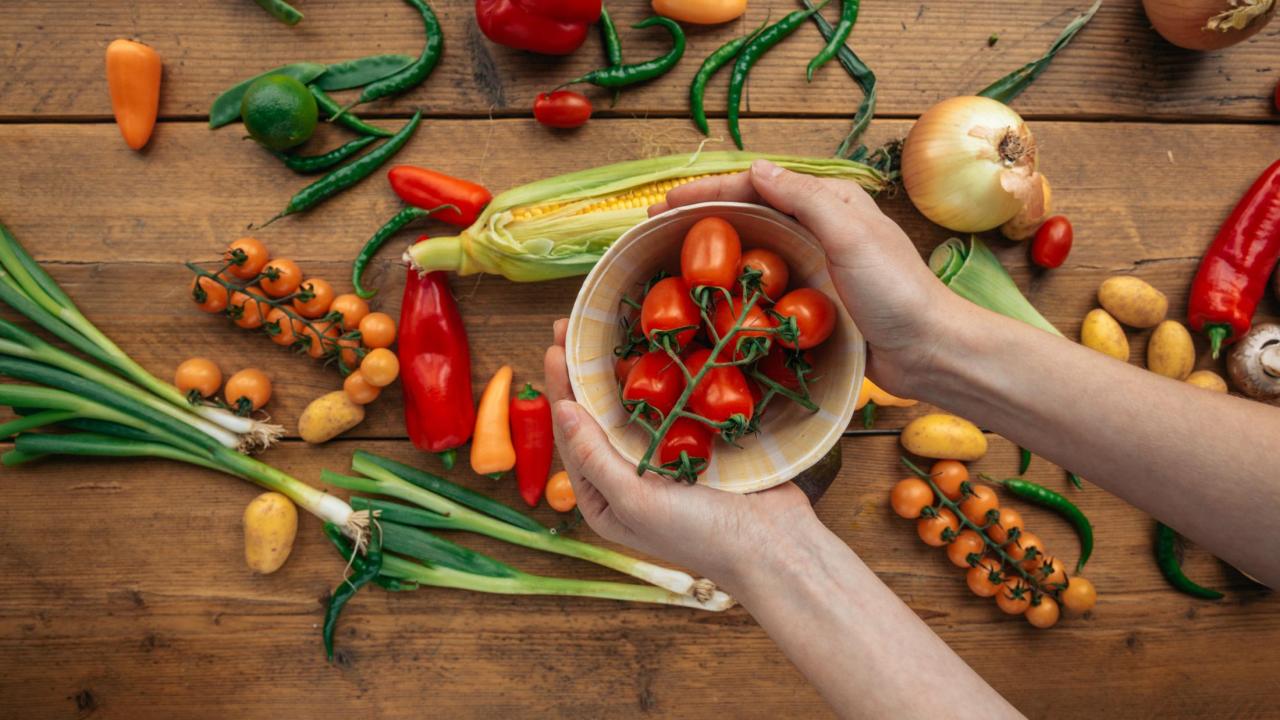 Person Holding a Bowl with Red Tomatoes