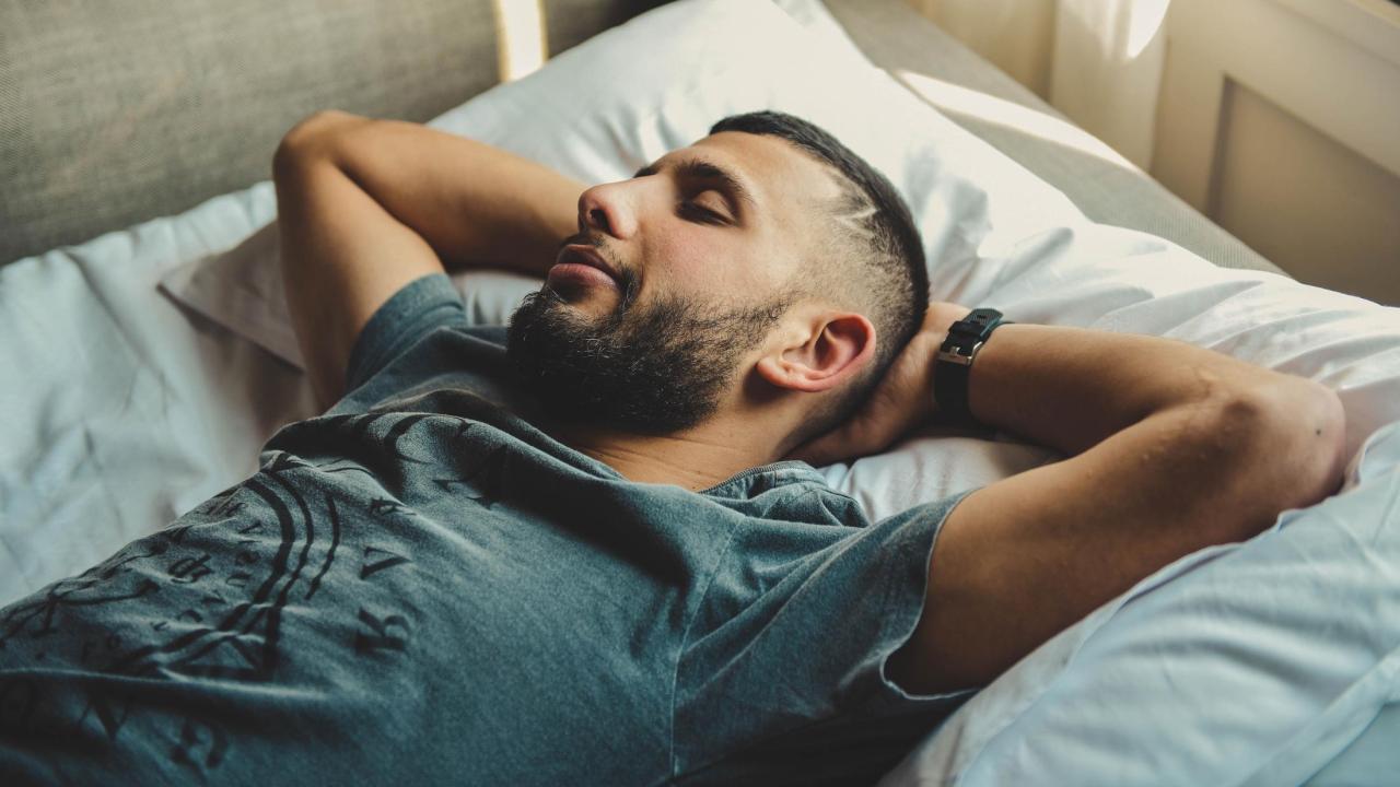 Man sleeping with hands behind head