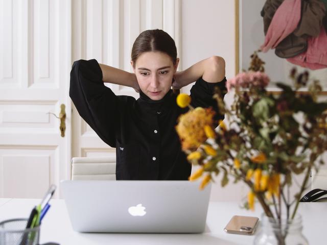 woman looking at her laptop and stretching