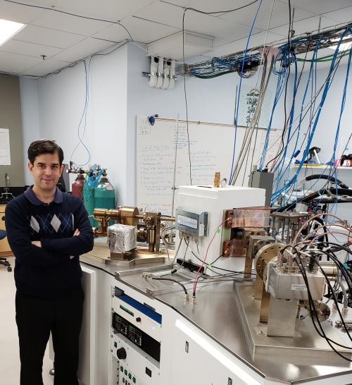 Dr. Sujoy Mukhopadhyay stands next to wires and equipment in his lab.