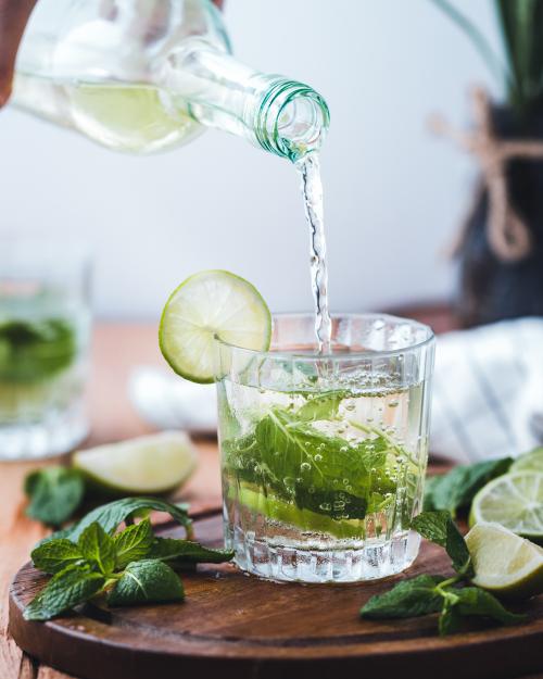 Water being poured into a glass with a cucumber