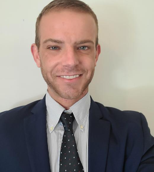 Headshot of a light-haired man in a suit.