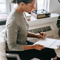 woman writing on clipboard