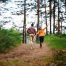 a man and woman walking joyfully in the forest