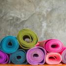 Pile of rolled up yoga mats in various bright colors