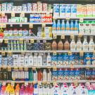 Image of a large stocked grocery store shelf filled with dairy milks, yogurts and juices