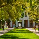 image of Mrak Hall Lawn and Egghead in springtime with four pedestrians walking