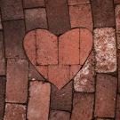a red heart brick in the middle of a red brick path
