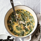 a hearty bowl of fresh kale soup on a stove with a ladle
