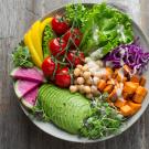 Salad bowl with avocado, figs, tomatoes, lettuce, chickpeas, cabbage, and more. 