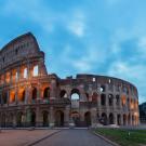 Image of the Coliseum in Rome with a cloudy blue sky in the background
