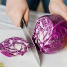 woman cutting a purple cabbage
