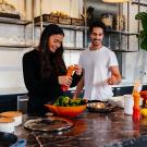 Man and Woman cooking together happily