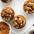 a batch of freshly baked pumpkin oat muffins on a table