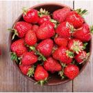 a bowl of fresh strawberries on a table